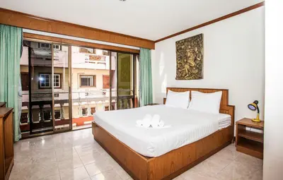a bedroom with a bed and a large window at Andaman Sea Patong in Patong Beach