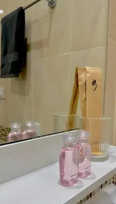 a bathroom counter with pink glass jars in front of a mirror at Супер апартаменты Найтон Naithon in Nai Thon Beach