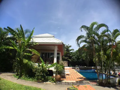 a house with a swimming pool and palm trees at Lemon House in Patong Beach