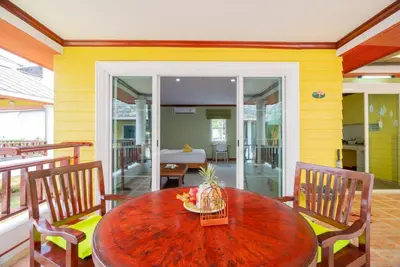 a dining room with a wooden table and chairs at Lemon House in Patong Beach