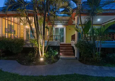 a house with palm trees in front of it at Lemon House in Patong Beach