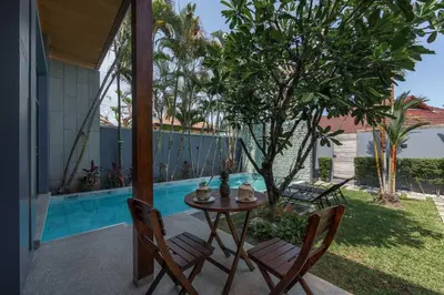 a patio with a table and chairs next to a pool at VILLA AWA Private Pool Naiharn beach in Rawai Beach