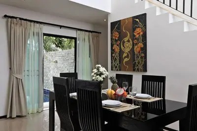 a dining room with a black table and chairs at VILLA Emauha Pool Thaimond Residence Naiharn in Rawai Beach