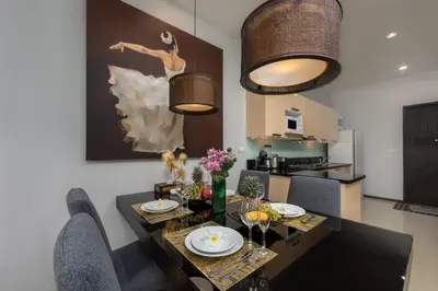 a dining room with a table and chairs and a painting at VILLA Iotama Private Pool Nai Harn Beach in Rawai Beach