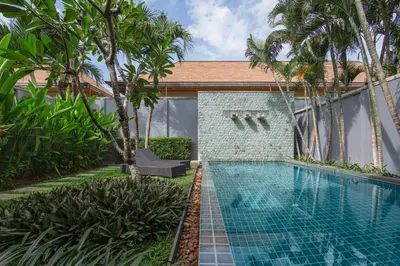 a swimming pool in front of a house with palm trees at VILLA JAVA Private Pool Nai Harn Beach in Rawai Beach