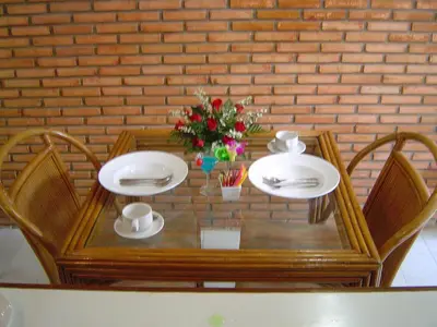 a wooden table with two plates and two chairs at Sunset Mansion in Patong Beach