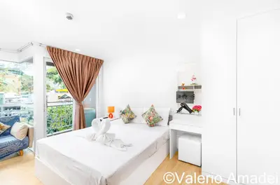 a white room with two beds and a window at Ozone Condotel Kata Beach by PHR in Kata Beach