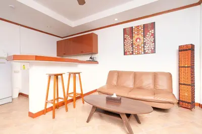 a living room with a couch and a table at Sai Rougn Residence - SHA Extra Plus in Patong Beach
