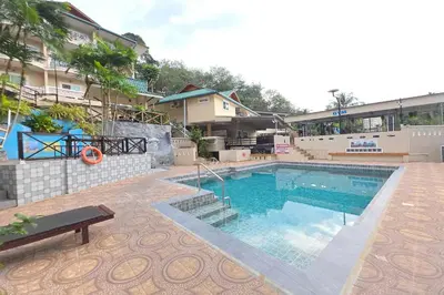 a swimming pool in front of a building at Patong Rai Rom Yen Resort SHA in Patong Beach