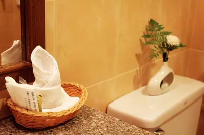 a bathroom with a basket of towels and a vase at Baan Pron Phateep in Patong Beach