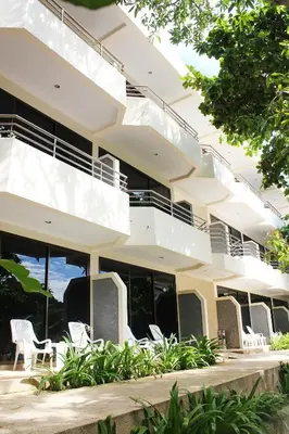 an exterior view of a building with white chairs at Baan Pron Phateep in Patong Beach