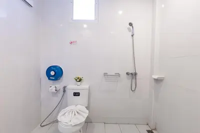a white bathroom with a shower and a toilet at Kasemsuk Hotel Karon in Karon Beach