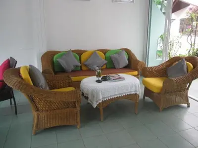 a living room with a couch and chairs and a table at Hacienda Phuket, Patong in Patong Beach