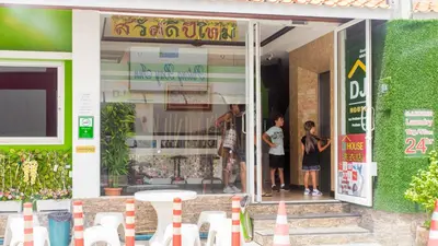 two children standing in a glass door of a store at DJ House ดีเจ เฮ้าท์ป่าตอง in Patong Beach