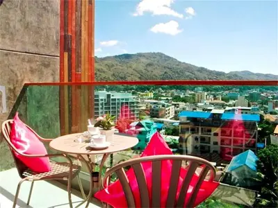 a table and chairs on a balcony with a view at Emerald Terrace Patong in Patong Beach