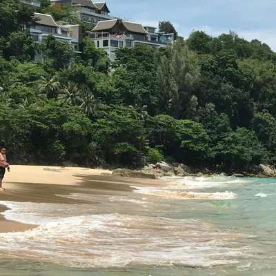a person walking on the beach near the water at Nai Thon Condo Unit in Nai Thon Beach