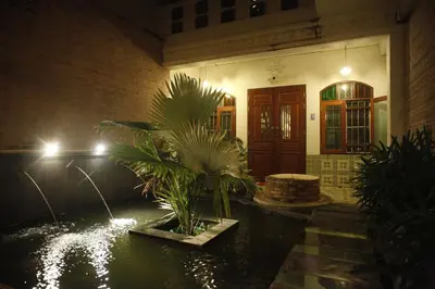 a house with a pond in front of a building at 99 Oldtown Boutique Guesthouse SHA EXTRA PLUS in Phuket Town