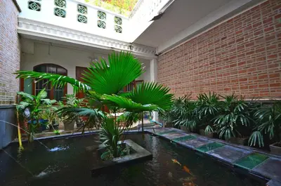 a room with a pond with plants and a brick wall at 99 Oldtown Boutique Guesthouse SHA EXTRA PLUS in Phuket Town