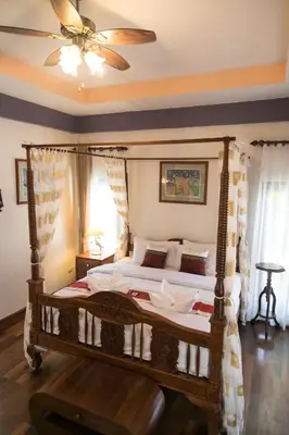 a bedroom with a canopy bed and a ceiling fan at West Key Kamala Villa in Kamala Beach
