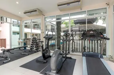a gym with treadmills and ellipticals in a building at Patong Lodge Hotel - Thailand's Green Hotel Plus in Patong Beach