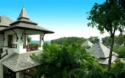 a view of a building with trees in the background at Nakamanda Resort and Spa in Klong Muang Beach