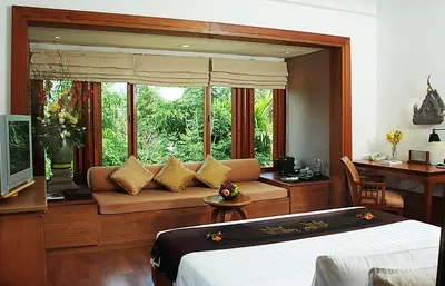 a bedroom with a bed and a window with a couch at Nakamanda Resort and Spa in Klong Muang Beach