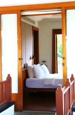 a bedroom with a bed with a glass door at Nakamanda Resort and Spa in Klong Muang Beach