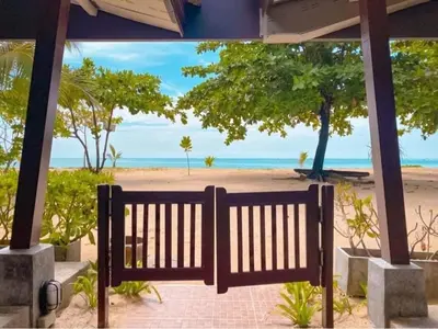 a bench in front of a beach with the ocean at Dang Sea Beach Resort - SHA in Nai Yang Beach