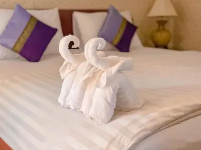 two swans made out of towels on a bed at Dang Sea Beach Resort - SHA in Nai Yang Beach