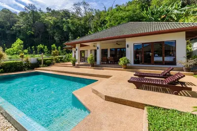 a swimming pool with two chairs and a house at Aster Pool Villa Your Tropical Villa In Paradise in Rawai Beach