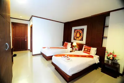 a hotel room with two beds and a window at Arita Hotel Patong in Patong Beach
