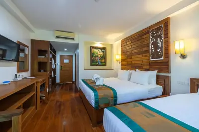 a hotel room with two beds and a desk at Phuket Meet Holiday Hotel-Rawai \u666e\u5409\u5c9b\u76f8\u9047\u82b1\u56ed\u5ea6\u5047\u9152\u5e97-\u62c9\u5a01\u5e97 in Rawai Beach
