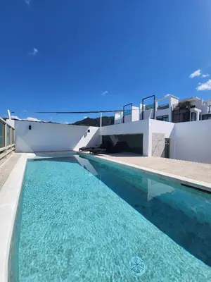a swimming pool with blue water in front of a house at The Regent Residence Kamala in Kamala Beach