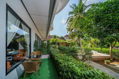 an outdoor patio with two chairs and a garden at Blue Carina Hotel Phuket in Phuket Town