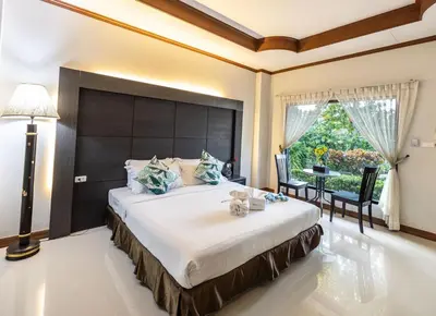 a bedroom with a large bed with a large headboard at Blue Carina Hotel Phuket in Phuket Town
