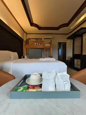 a bedroom with a bed with a tray of food at Blue Carina Hotel Phuket in Phuket Town