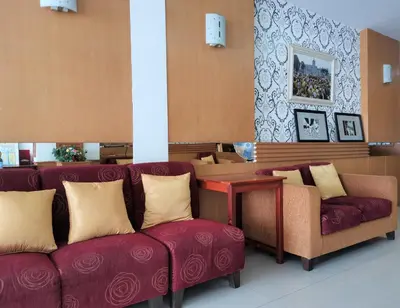 a waiting room with two red couches and a table at Le Desir Resortel in Chalong