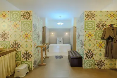 a room with a bedroom with a bed and a wall at Perennial Resort in Nai Yang Beach