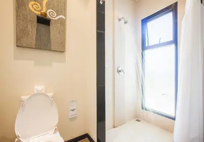 a white toilet in a bathroom with a window at One Bedroom Oriental Villa Nai Harn in Nai Harn Beach