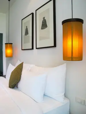 a bedroom with a white bed with three pictures on the wall at Villa 1 Bedroom with private pool at Oxygen Bangtao in Bang Tao Beach