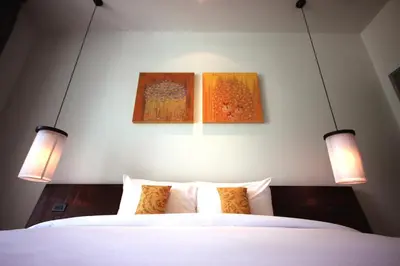 two lights above a bed with two pictures on the wall at Villa 2 Bedrooms with private pool at Oxygen Bangtao in Bang Tao Beach