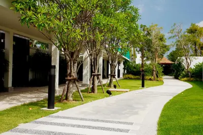 a walkway in front of a house with trees at Villa 4 Bedrooms with private pool at Oxygen Bangtao in Bang Tao Beach