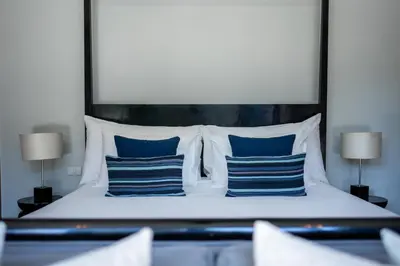 a bedroom with a bed with blue and white pillows at Villa 1 Bedroom with private pool at Wings Pasak in Bang Tao Beach