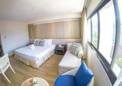 a small room with two beds and a couch at Hiran Residence in Patong Beach
