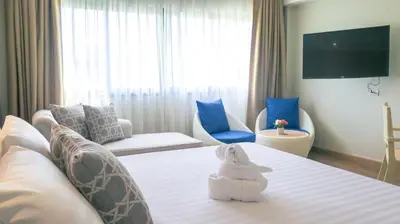 a hotel room with a white stuffed animal sitting on a bed at Hiran Residence in Patong Beach