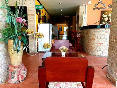 a room with a table and a chair and flowers at Andaman House SHA Plus in Patong Beach