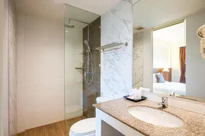 a bathroom with a sink and a shower and a toilet at Orchid Garden Hotel Patong in Patong Beach