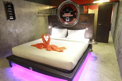 a bedroom with a bed with two stuffed animals on it at Nicky's Handlebar in Patong Beach