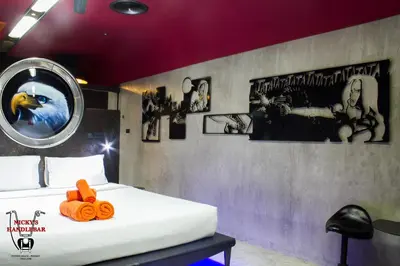 a bedroom with a bed and posters on the wall at Nicky's Handlebar in Patong Beach