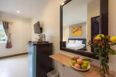 a room with a mirror and a bowl of fruit on a counter at Baan Yuyen Karon Guesthouse in Karon Beach